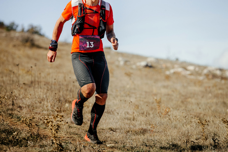 Young male athlete runner running mountain trail