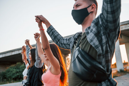 Hermoso amanecer. grupo de jóvenes que protestan que se unen. activista por los derechos humanos o contra el gobierno