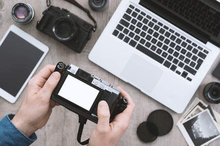 Professional photographic equipment tablet and laptop on a desktop a photographer is checking pictures previews on the camera display Stock Photo