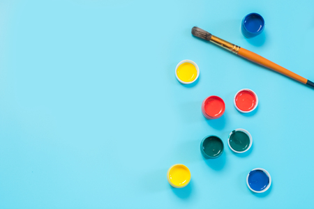 Back to school colorful paints and brush on punchy blue copy space top view Stock Photo