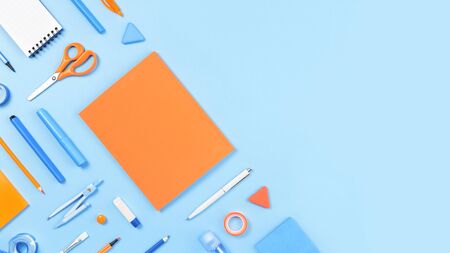 Assorted office and school white orange and blue stationery on pastel trendy background as border flat lay with copy space for back to school or education and craft concept blue monochrome banner Stock Photo