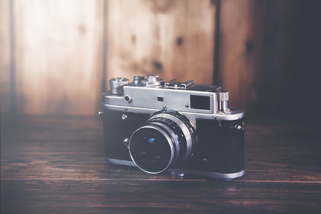 Retro camera on wood table background