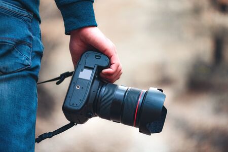 Man hand camera in the autumn forest