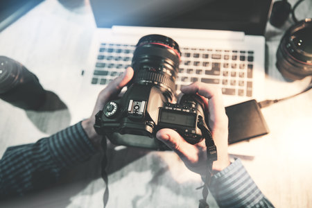 Photographer hand camera on desk