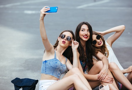 Trzy młode piękne dziewczyny na ulicy robić zdjęcia Zdjęcie Seryjne