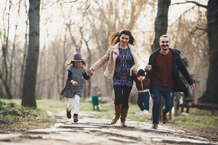 Familia feliz caminando en el parque de otoño
