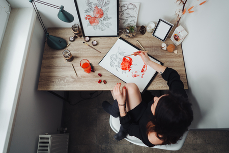 Young woman painting with watercolor paints