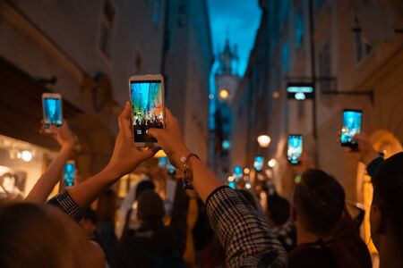 la multitud mira con interés la actuación en la calle y la graba en smartphones Foto de archivo