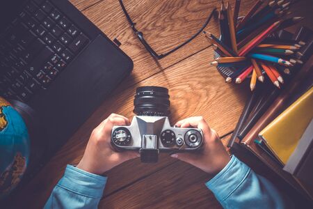 Desktop of a little kid photographer top view camera and laptop on a wooden table