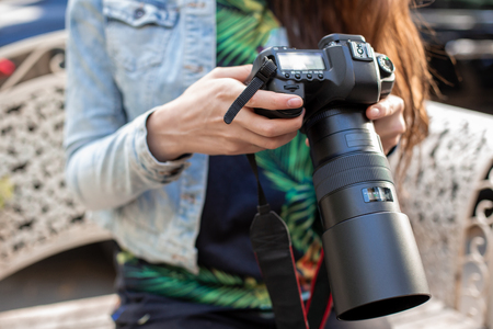 Close up of female hands holding a professional camera female photographer with a professional camera