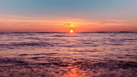 La playa de la puesta del sol tropical de la onda lisa y la onda ligera del sol del bokeh texturizan el fondo. Copiar el espacio de las vacaciones de verano y el concepto de aventura de viaje. Poca profundidad de campo. Estilo de color de efecto de filtro de tono vintage.