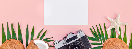 Creative flat lay top view mock up green tropical palm leaves coconuts blank paper card old photo camera pink background copy space minimal tropical palm leaf plants summer travel concept template