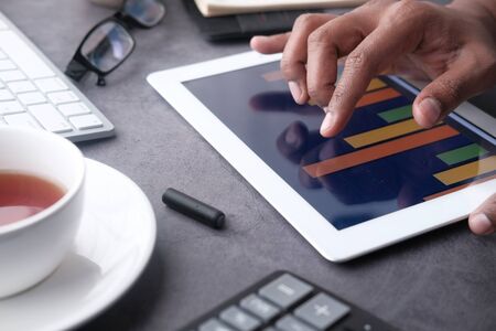 Person hand analyzing financial data in digital tablet