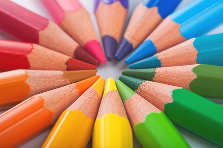 Color pencils in arrange in color wheel colors on white background