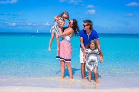 Familia de cuatro jóvenes en la playa blanca tropical Foto de archivo