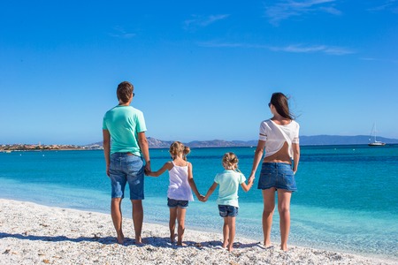 Hermosa familia joven con dos niños en las vacaciones de verano tropical