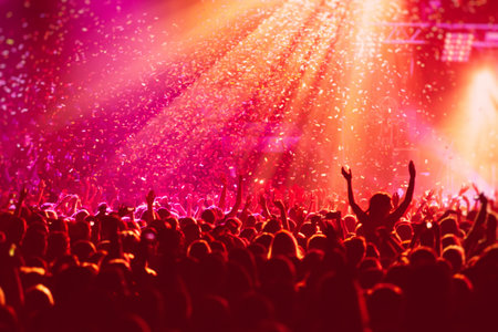 A crowded concert hall with stage stage in red lights rock show performance with people silhouette colorful confetti explosion fired on dance floor during a festival concert