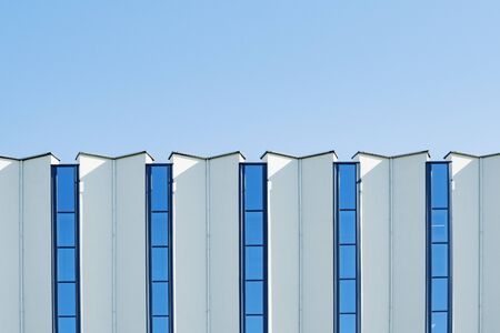 A fragment of the building s facade with colored vertical windows Stock Photo