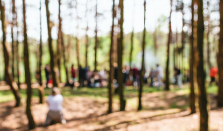 A blurry image of a lot of people relaxing in a pine forest