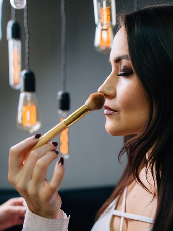 Make up artist doing professional make up of woman