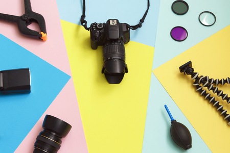 Photo camera and accessories equipment on multicolor background