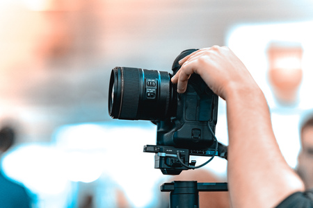 Video shooting with a camera with a tripod with a black stabilizer the background is blurred