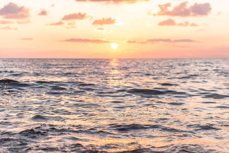 Puesta de sol sol y primer plano de las olas. Colores anaranjados del sol bajo en el Mar Mediterráneo. Foto de archivo