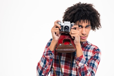 Portret młody afro amerykański mężczyzna robi fotografii na retro kamerze odizolowywającej na białym tle