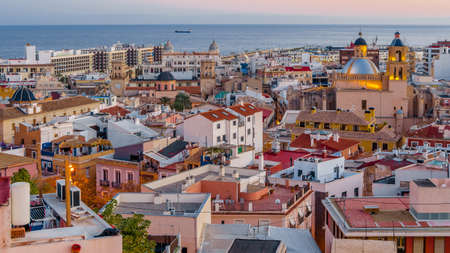 Paisaje urbano de Alicante al atardecer, mostrando la catedral con el mar de fondo