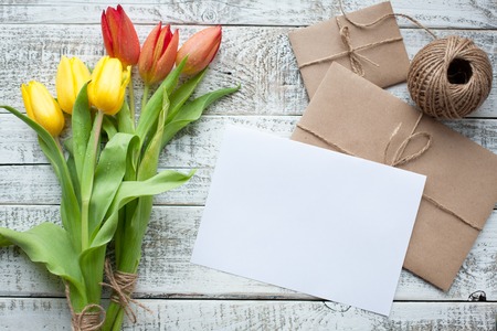 Frische gelbe Tulpen und leeres Tag auf aquamarinem hölzernem Hintergrund . Geringe Tiefenschärfe . Platz für Text . Quadratisches Bild