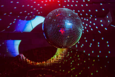 Party disco mirror ball reflecting purple lights