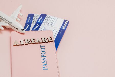 Aufschrift "Flugpreis", Flugzeug, Flugticket und Geld auf rosafarbenem Hintergrund. Reisekonzept, Kopierraum. Standard-Bild