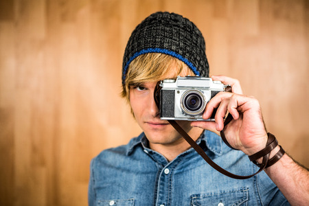 Serieuze hipster man die foto's maakt met digitale camera