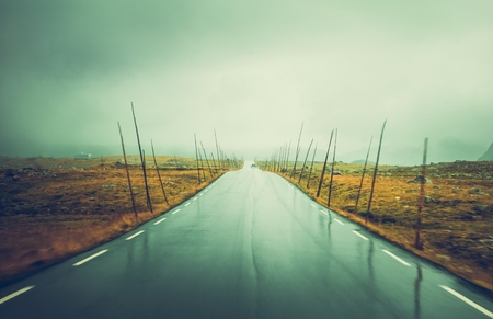 Mountain road through the norwegian wilderness foggy and rainy weather ahead scandinavian road trip theme