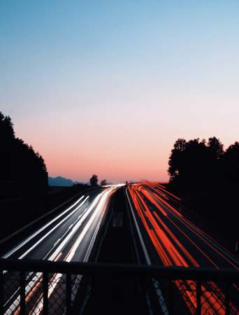 A long exposure shot of car lights on the highway during sunset