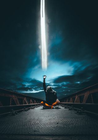 A man on the bridge sending magical power to heaven at night Stock Photo