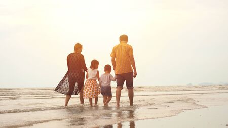 Feliz familia asiática disfrutando de un paseo por la playa Foto de archivo