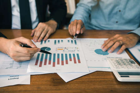 Two businessmen discussion analysis sharing calculations about the company budget and financial planning together on desk at the office room