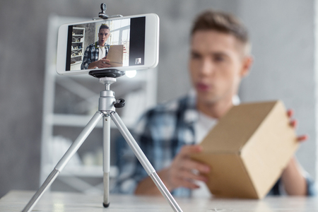 My project good looking inspired young well built man talking and holding his box while making a video