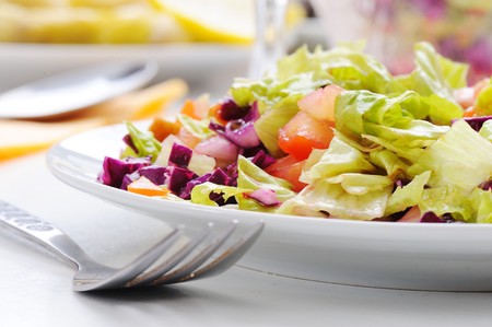 Fresh green salad prepared on white meal table