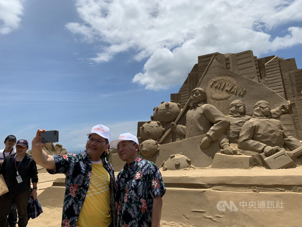 交通部長林佳龍（右2）與衛福部長陳時中（右）29日出席2020福隆國際沙雕藝術季活動，兩人在防疫國家隊的沙雕前自拍。中央社記者葉臻攝　109年6月29日