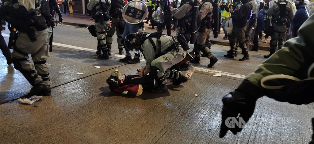 中國全國人大常委會30日通過「港區國安法」，港台引述消息表示，法例沒有提及追溯力，但過往2年從事危害國家安全的人繼續涉嫌犯事，曾涉嫌犯事的證據可能成為法庭上的舉證參考。圖為1月香港遊行港警逮捕示威者。（中央社檔案照片）