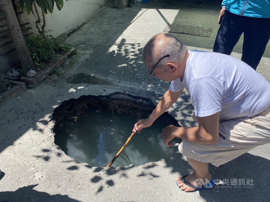 彰化縣彰化市中興路186巷的道路6日上午突然出現一個坑洞，附近民眾拿竹竿測試，發現坑洞深約1公尺。由於附近有興建大樓工地，施工單位已先回填水泥，穩固地基。（翻攝畫面）中央社記者吳哲豪傳真　109年8月6日