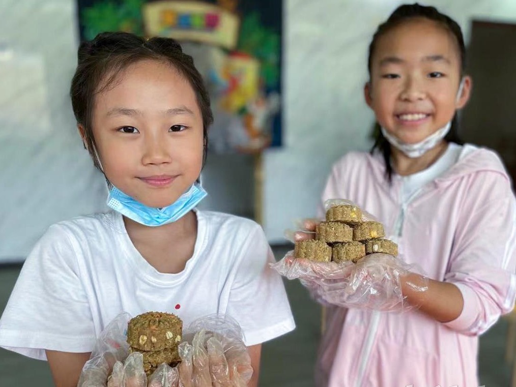 孩子们在武汉野生动物王国给猴子做月饼