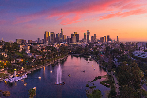 Una veduta aerea di Los Angeles, con un parco e un lago in primo piano e i grattacieli della città sullo sfondo.