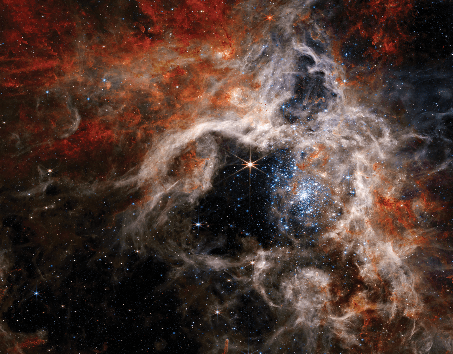 Space image with stars and swirls of colorful orange, red and white.