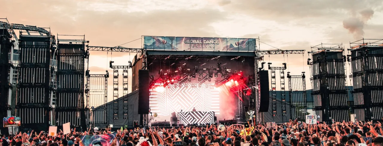 A concert with a lot of people in the sunset.