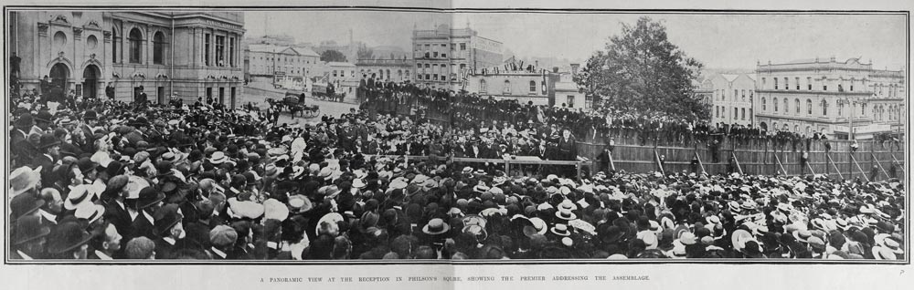 Panoramic view of a large crowd assembled in front of group of speakers