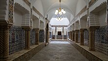 Hallway lined by pillars decorated with patterned tiles