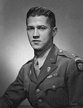 A young looking Caucasian man with dark hair and eyes in a US Army uniform with several decorations